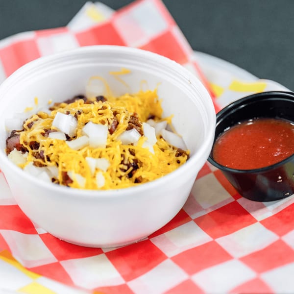 Casa del Taco's chili with shredded cheese and diced onions, served with a side of salsa.